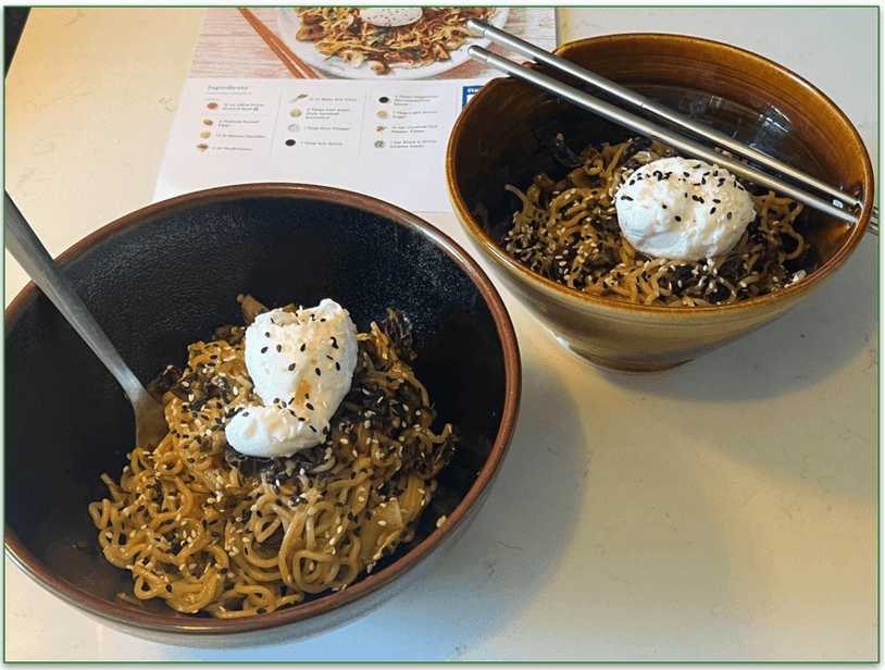 Our reviewers own image of mushroom ramen that they cooked with recipe card in the background