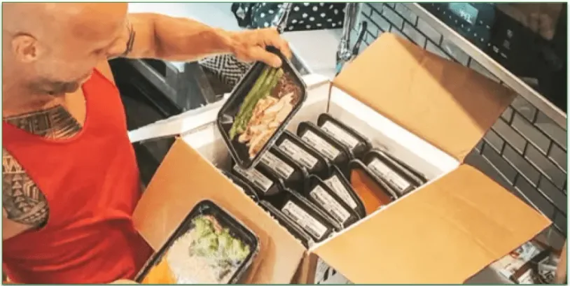 A man unpacking a box of Icon Meals