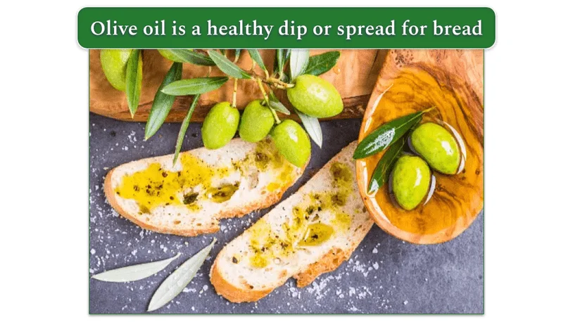 olive oil on bread with green olives surrounding bread