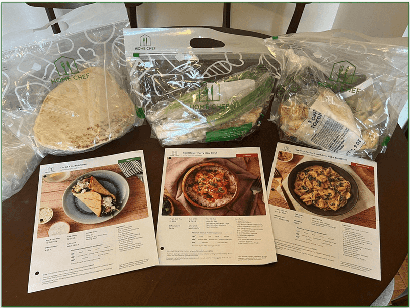 Three Home Chef recipe cards and three corresponding bags of ingredients