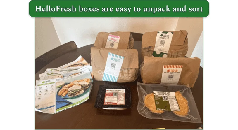 Our reviewers HelloFresh order unpacked showing 4 paper bags filled with ingredients and 4 recipe cards