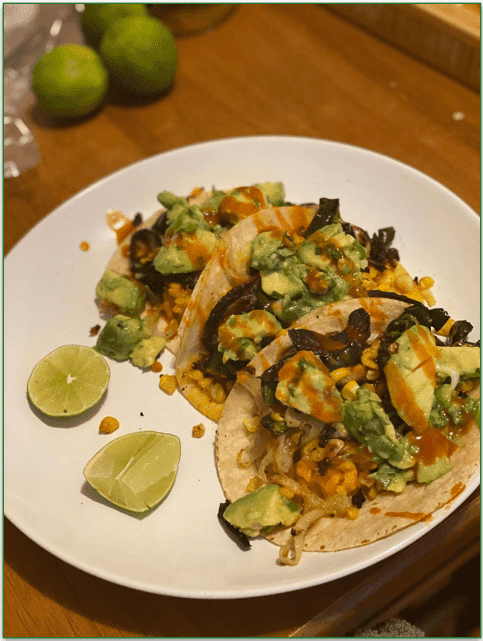 Purple Carrots Rajas Tacos on a plate alongside limes