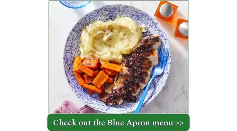A plate of chicken blueberry sauce, roasted carrots, and mashed potatoes