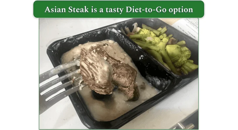 Diet-to-Go's Asian Steak dish in a microwaveable tray with a piece of steak lifted on a fork