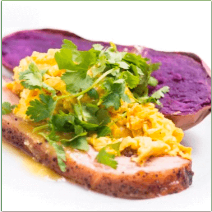 A slice of smoked pork belly topped with eggs and a side of organic purple sweet potato. 