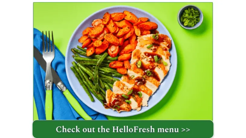 A sliced pork chop with green beans and carrots