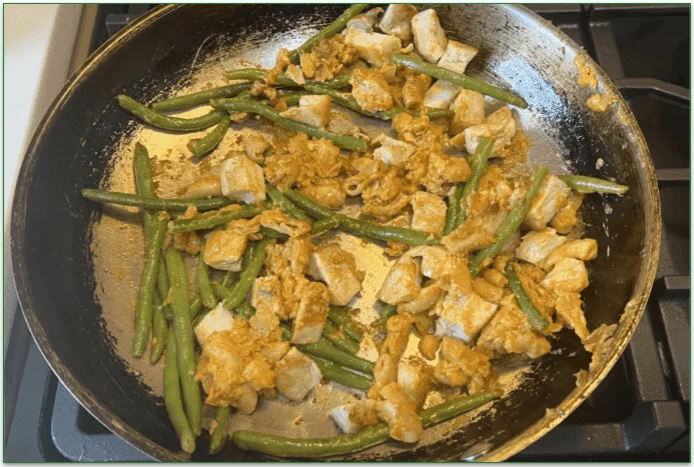 Photo of the dish being heated in a skillet on the stove