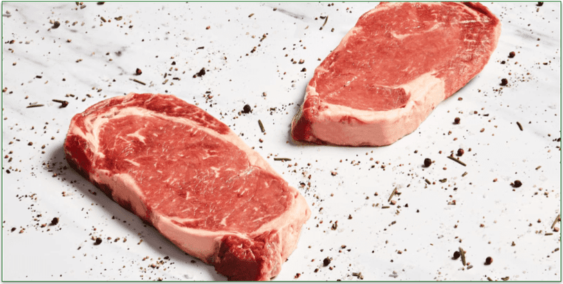 two steaks on a marble table