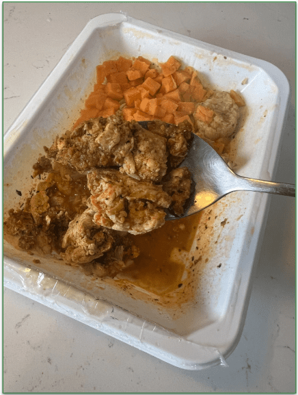 Closeup on a piece of chicken from a Trifecta dish