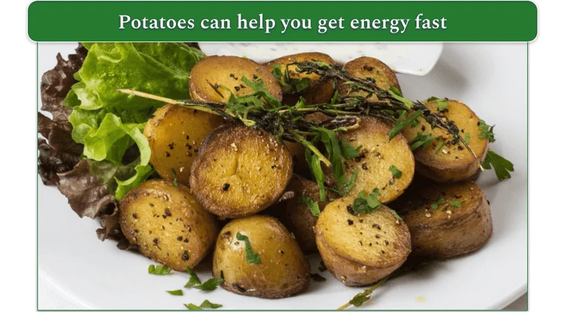 Baked potatoes cut in half with two lettuce leaves on the plate.