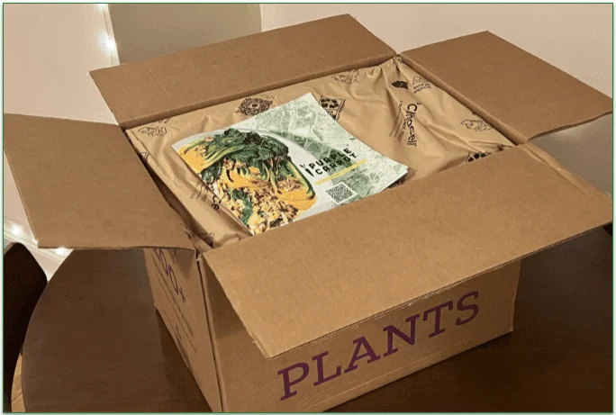 Open Purple Carrot delivery box with a recipe booklet on top of the insulation layer