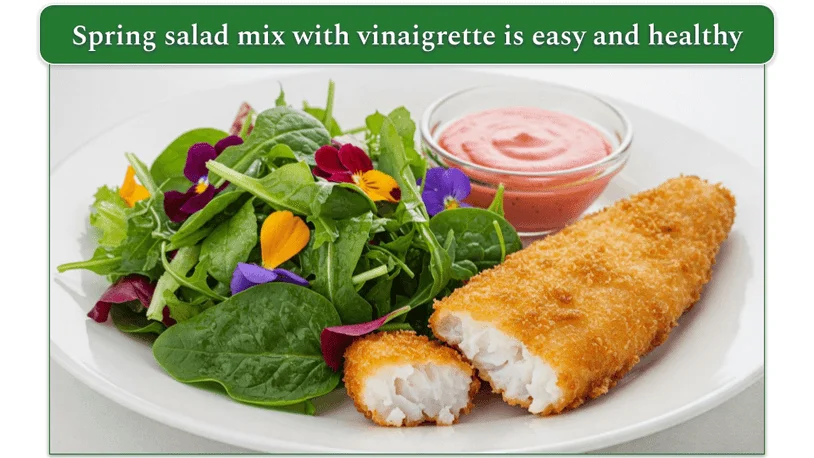 A piece of fried fish on a plate beside some raspberry lemon vinaigrette.