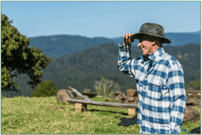 A farmer staring off into the distance, smiling.
