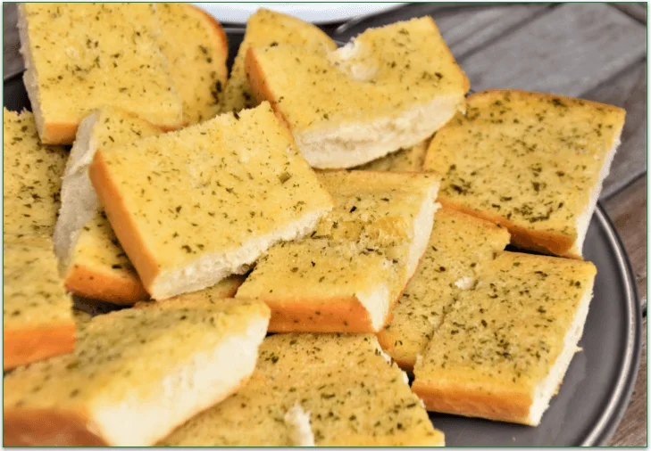 Slices of garlic bread served on a plate