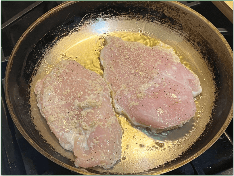 Chicken breasts cooking in a pan