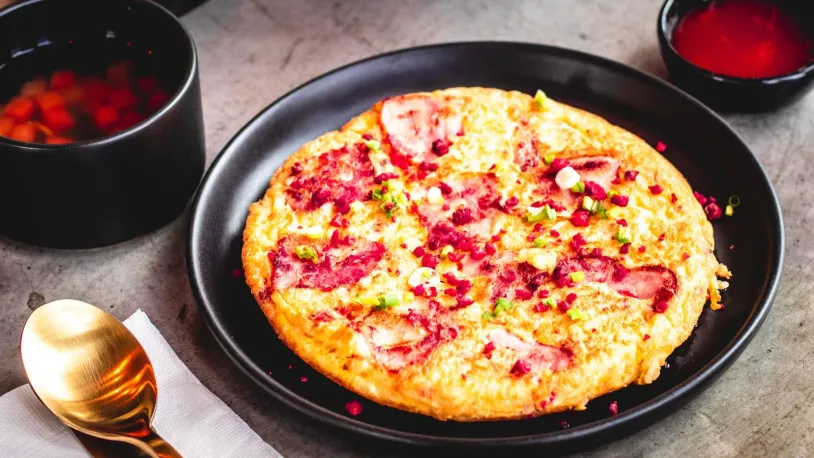 A bacon and tomato pizza with a potato base