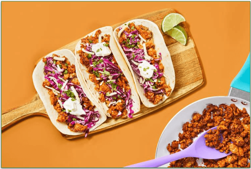 Three Tacos on a Cutting Board
