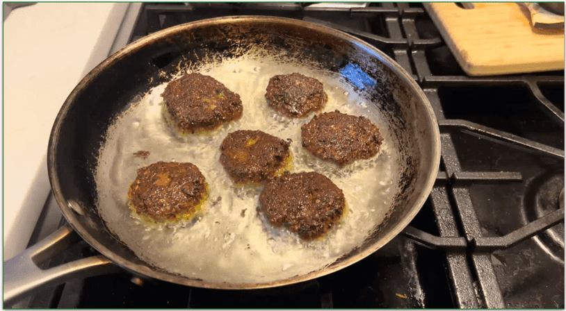 Falafel patties frying in a pan