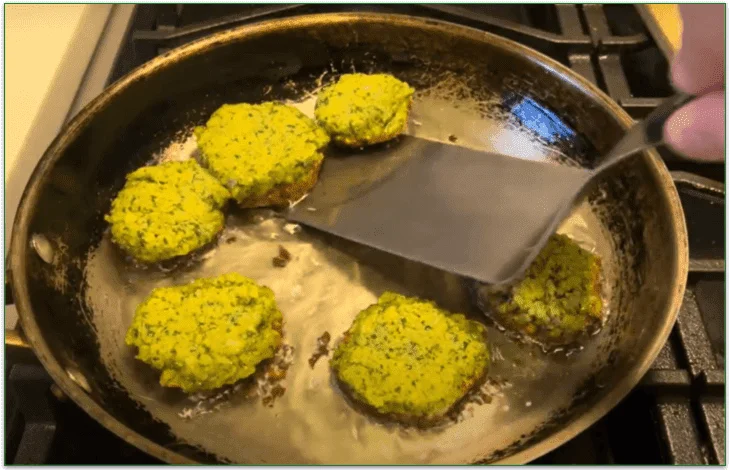 Image of falafel in a pan with oil being turned with a spatula