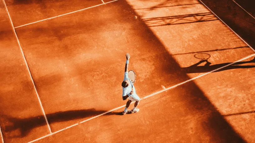 A tennis player mid-serve