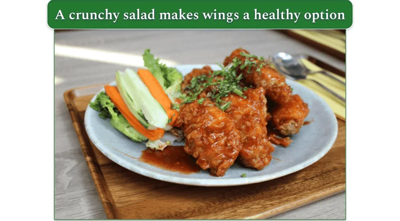 Honey Garlic Wings next to Cucumber Salad, on a plate
