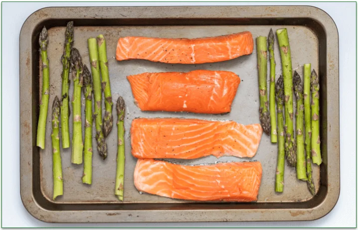 Salmon fillets and asparagus spears on a sheet pan