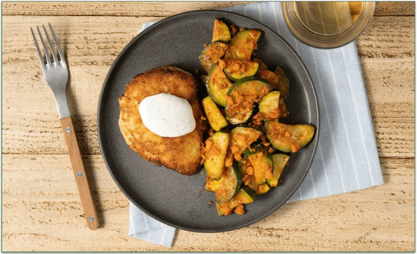 A plate of fried chicken with sauteed zucchini