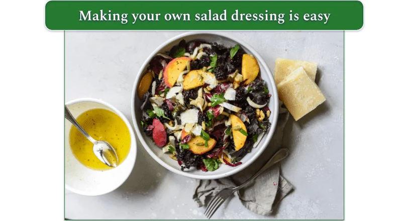 A multi-colored salad in a bowl alongside a dish of homemade vinaigrette