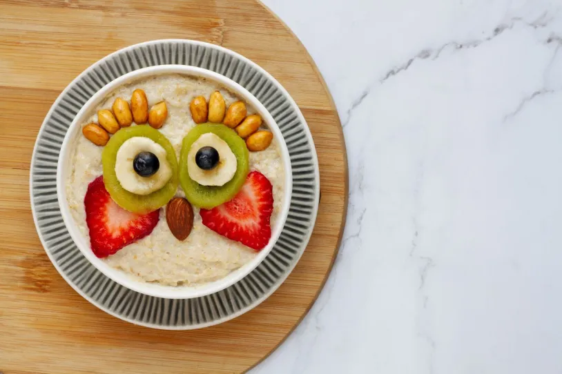 <span>Cooked oats topped with mixed fruit in the shape of a face</span><br>