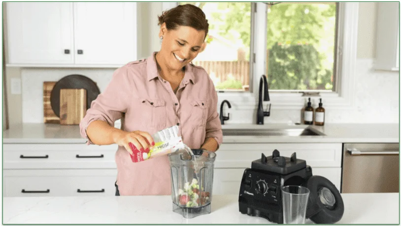 Woman pouring ingredients into a blender