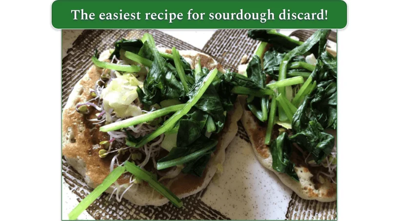 Sourdough pancakes served on a plate with sauteed spinach, sauerkraut, and sprouts