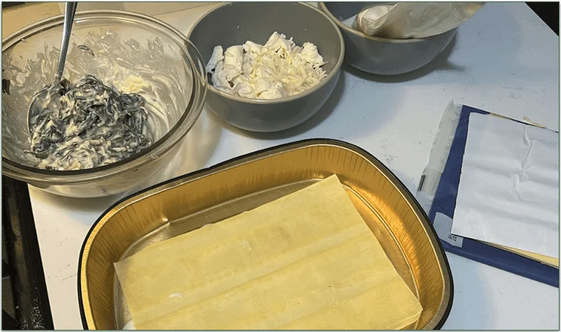 Photo of 3 dishes containing different elements of the Lasagna recipe and lasagna sheets in the aluminum baking tray ready for layering