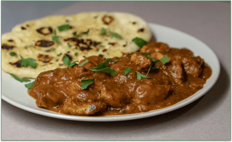Chicken tikka masala and naan bread served on a plate