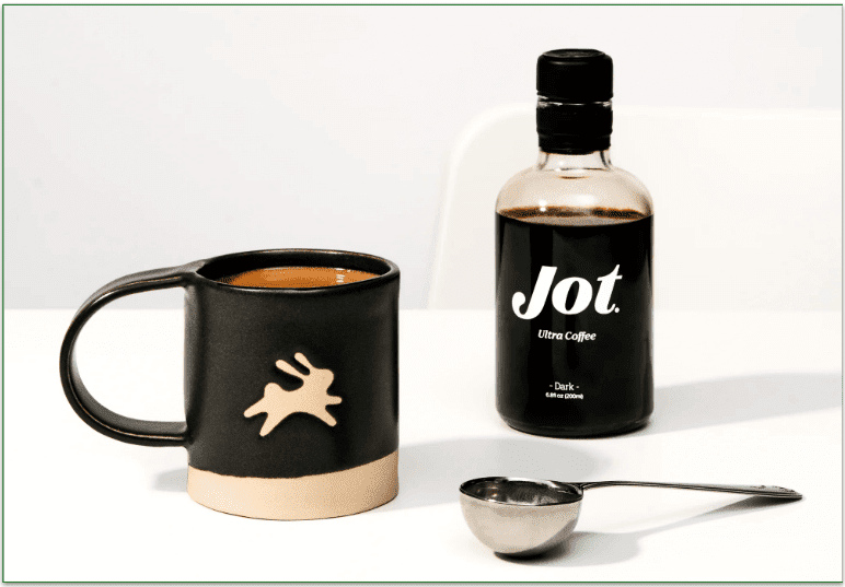 Image of Jot's Dark bottle next to a coffee mug and scoop
