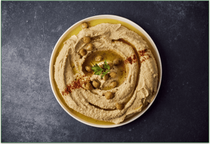 A bowl of hummus on a table.