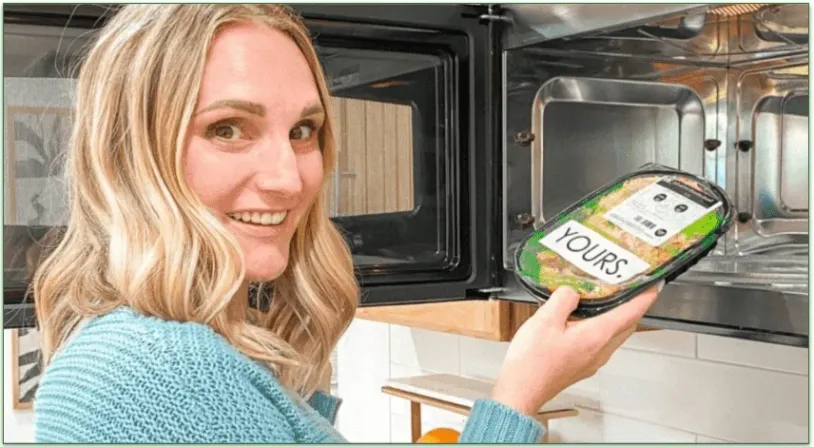 Woman placing a meal in the microwave