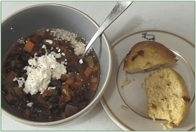 Black Bean Chili served in a bowl next to cornbread on a plate