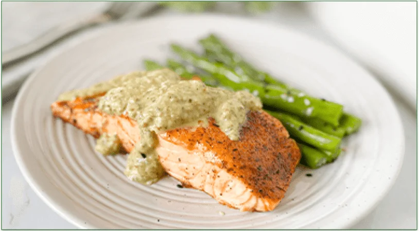 cooked salmon filet with chimichurra sauce and cooked asparagus