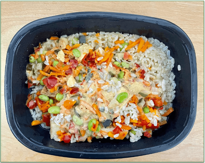 Vegetable red curry with tofu in microwave safe container