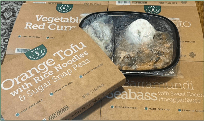 Spread of BistroMD meals in their trays with Orange Tofu on the top
