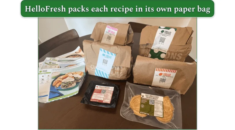 Four HelloFresh bags each containing one recipe with proteins in front of the bags