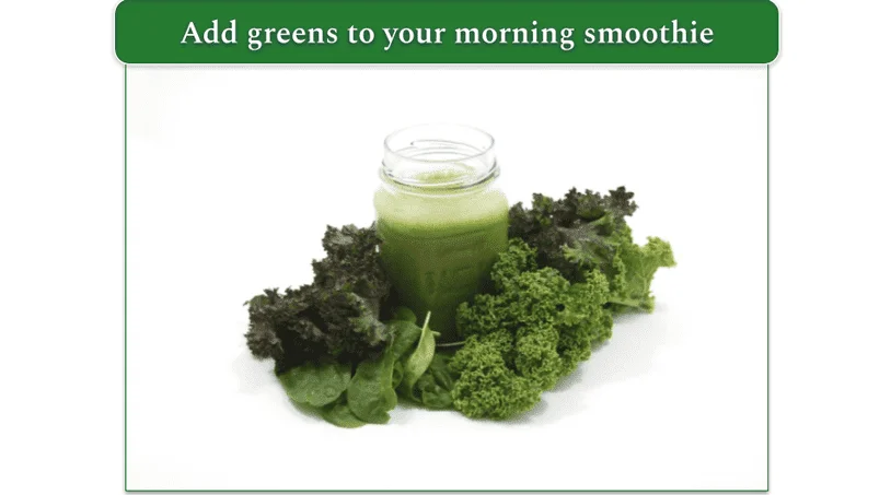 A green smoothie surrounded by kale and spinach