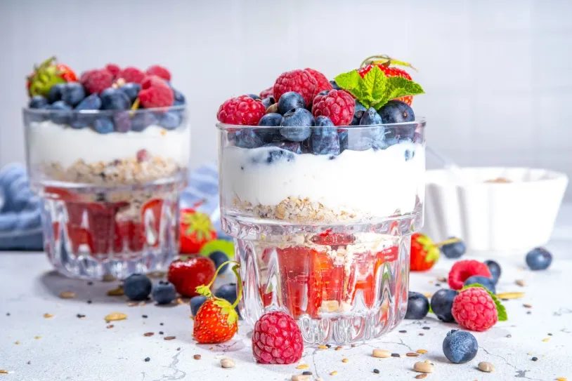 Yogurt parfait in a glass topped with strawberries and blueberries