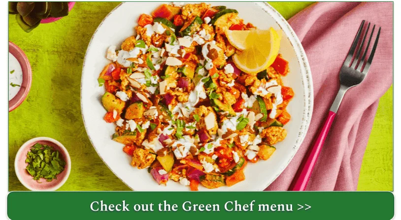 A turkey tagine with colorful  vegetables and a slice of lemon.