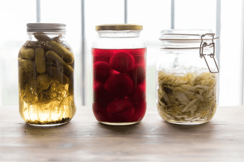 Jars of fermented foods including pickles and cabbage
