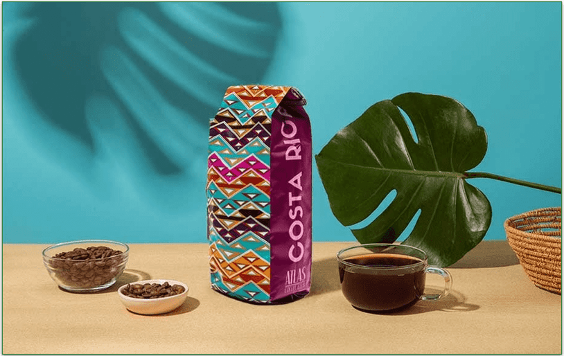 Image of Atlas Coffee Club's Costa Rican coffee with whole beans, a bag of coffee, and a cup of coffee displayed