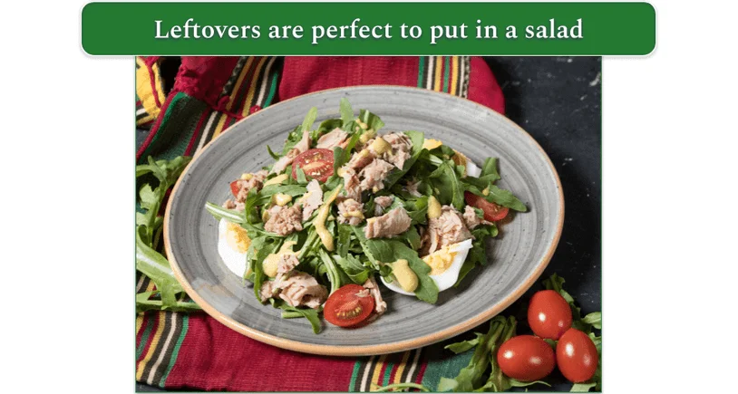 A salad topped with shredded tuna and hard boiled eggs