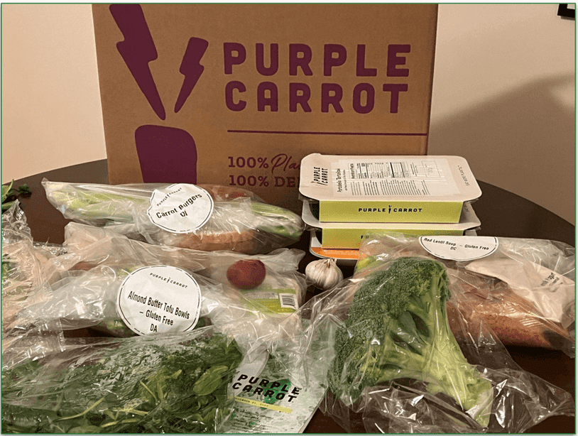Image of an unboxed Purple Carrot order showing individually wrapped ingredients in plastic