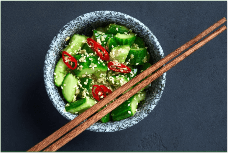 Cucumber salad in a bowl with chili slices and sesame seeds