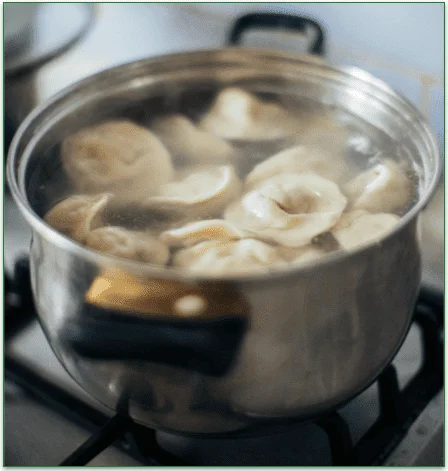Wonton cooking in a pot with almost-boiling wate